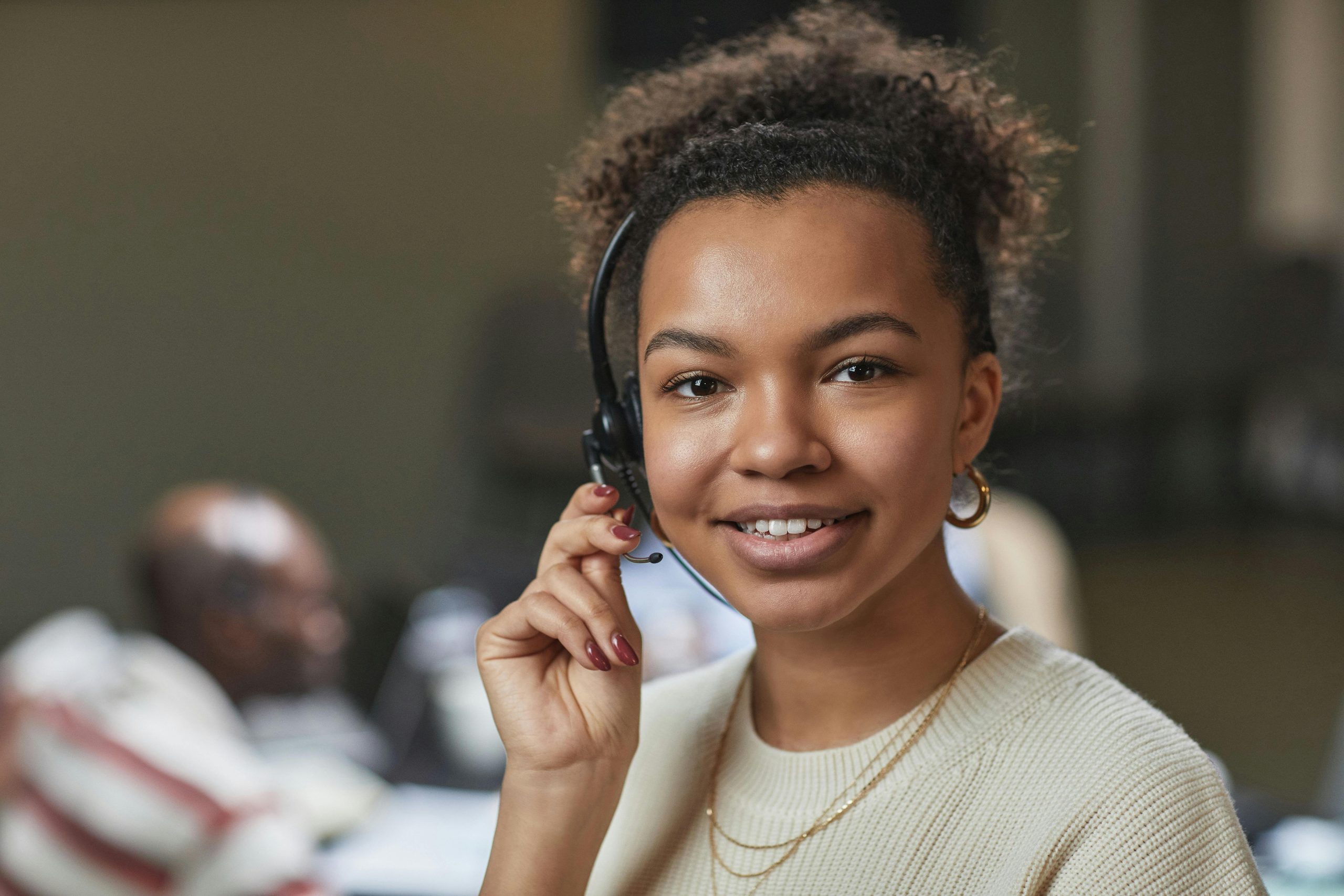 Woman wearing headset and smiling at the camera.